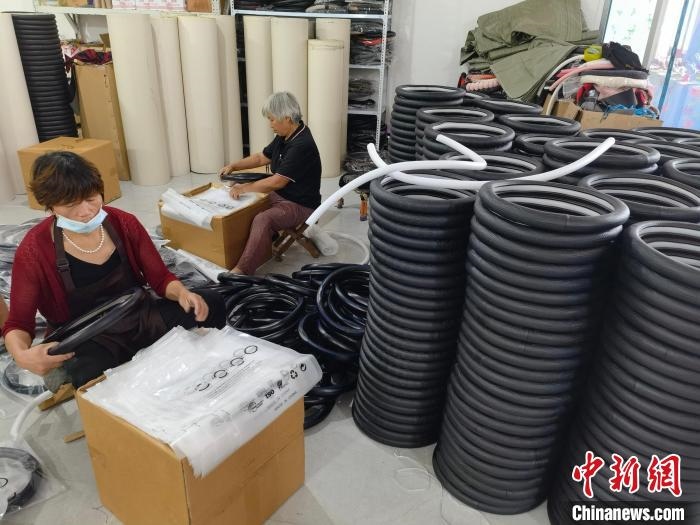 圖為村民在汽車飾品企業(yè)生產(chǎn)車間中工作?！巫雍?攝