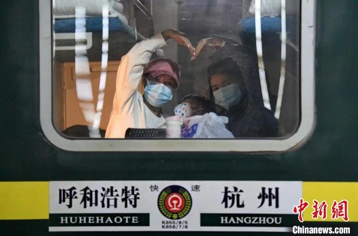 圖為登上轉(zhuǎn)運(yùn)火車的游客向額濟(jì)納比心?！⊥趵?攝