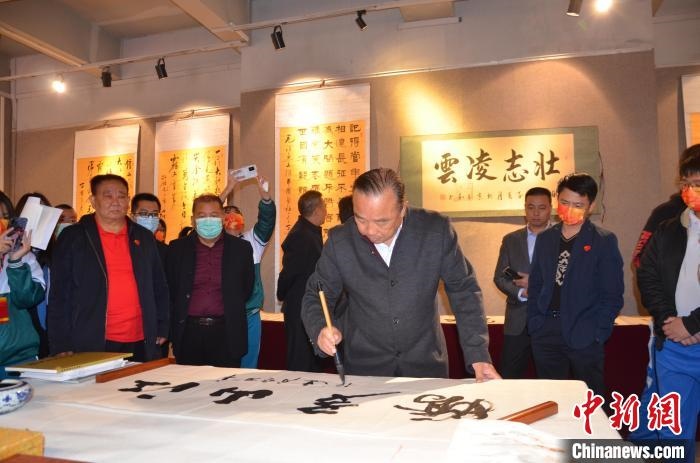 圖為“鐵軍老戰(zhàn)士”、著名書法家、解放軍報(bào)原副總編輯連俊義少將現(xiàn)場揮毫?！☆佇玛?攝 攝