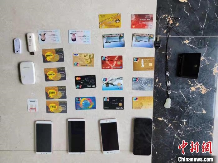 資料圖為果洛藏族自治州公安民警查扣的作案手機(jī)和涉案銀行卡。　瑪沁縣公安局供圖