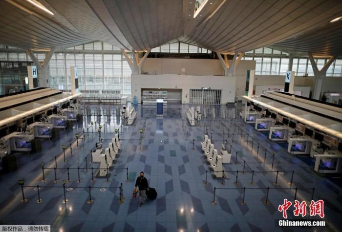 資料圖：日本東京，東京國際機場，一名乘客在國際航班航站樓的登機區(qū)。
