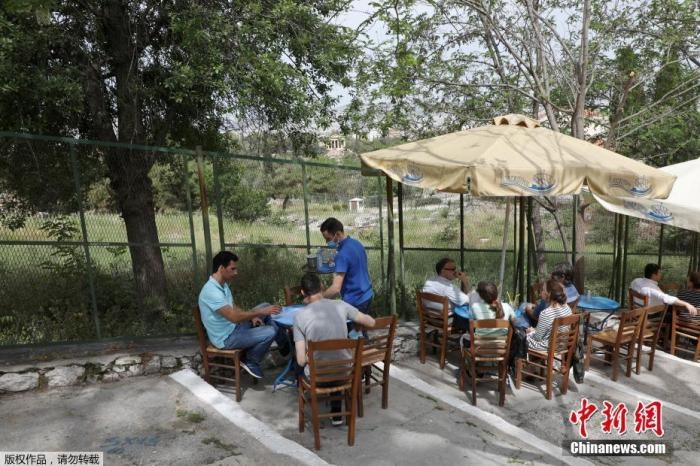 資料圖：希臘雅典，人們在一家露天咖啡享用飲品。