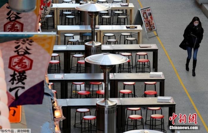 資料圖：日本東京，一名路人路過(guò)空蕩的戶外餐館。