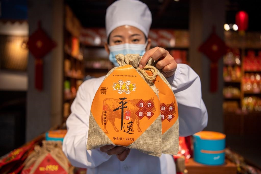 1月27日，在平遙古城南大街的一家平遙牛肉店內(nèi)，工作人員展示一款牛肉產(chǎn)品。新華社記者 楊晨光 攝