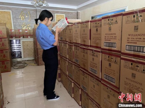 資料圖為檢察人員核對查獲的假冒品牌白酒。青海省人民檢察院供圖
