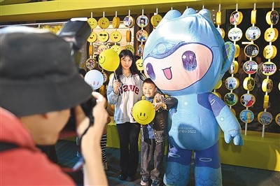 5月7日，在浙江省杭州市湖濱步行街“3D笑臉墻”前，攝影師為游客與杭州亞運(yùn)會吉祥物之一“宸宸”拍攝合影。