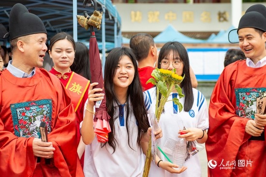 6月7日上午，在南寧市天桃實(shí)驗(yàn)學(xué)校翠竹校區(qū)，老師們?cè)跒榭忌鷤兗佑凸膭?！人民網(wǎng)記者 嚴(yán)立政攝