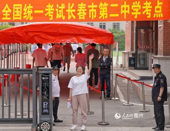 6月7日，在長(zhǎng)春市第二中學(xué)考點(diǎn)，一名考生信心滿滿進(jìn)入考場(chǎng)，并與家長(zhǎng)揮手致意。人民網(wǎng)記者 李洋攝