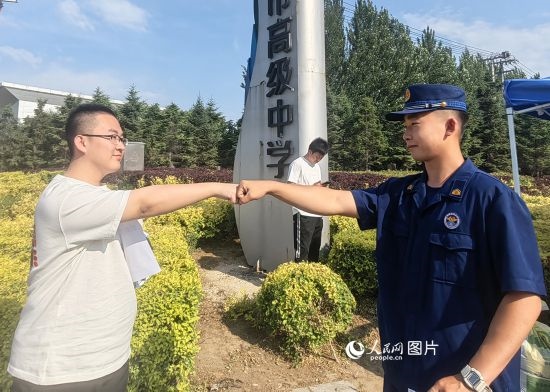 6月7日，遼寧營(yíng)口老邊區(qū)消防救援大隊(duì)的消防員為高考學(xué)子加油助威。人民網(wǎng)記者 尹柏寒?dāng)z