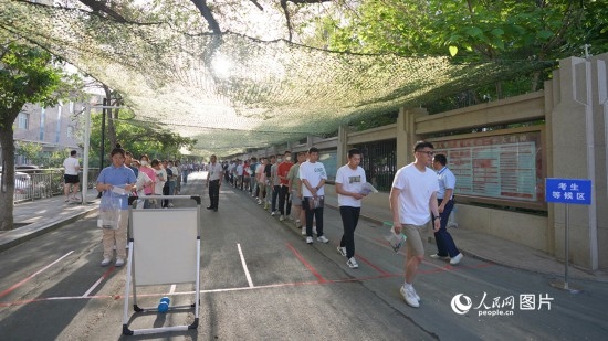6月7日，烏魯木齊市第七十中學(xué)門口，考生們有序進(jìn)入考場(chǎng)。人民網(wǎng) 李欣洋攝