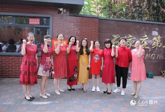 6月7日，在石家莊第二十七中學(xué)考點(diǎn)，家長(zhǎng)身著旗袍，為高考的孩子們加油助威！紅紅火火、旗開得勝！人民網(wǎng)記者 周博攝