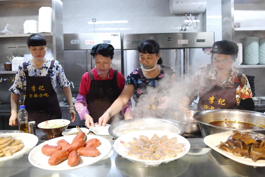 福建三明市沙縣區(qū)一家小吃店工作人員在為客人準備特色小吃。 新華社記者 林善傳 攝