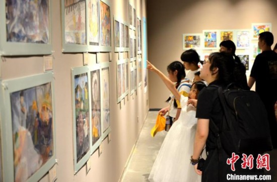 圖為家長帶著孩子參觀展覽。呂明 攝