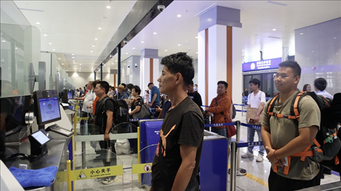 6月13日，乘坐中老鐵路國(guó)際旅客列車的旅客在磨憨邊檢大廳排隊(duì)候檢。李揚(yáng) 攝