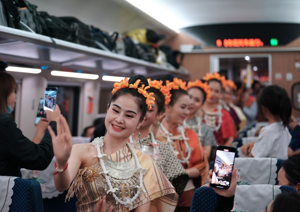 2023年4月13日，老撾工作人員在D887次國際旅客列車上表演。當(dāng)日，中老鐵路從中國昆明南站、老撾萬象站雙向?qū)﹂_D887次和D888次國際旅客列車，兩地乘火車可當(dāng)日通達(dá)。中老鐵路是高質(zhì)量共建“一帶一路”的標(biāo)志性工程。新華社記者 邢廣利 攝