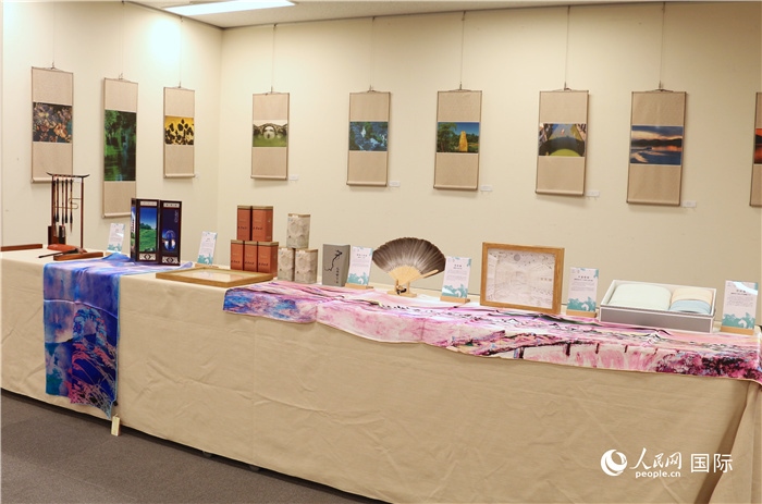 現(xiàn)場展出的馮學(xué)敏攝影作品與湖州市特色工藝品。（人民網(wǎng) 許可攝）