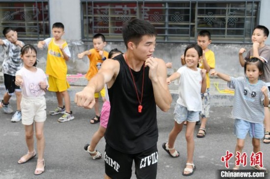 圖為大學(xué)生志愿者在組織孩子們參加體育健身活動(dòng)。廖光福 攝