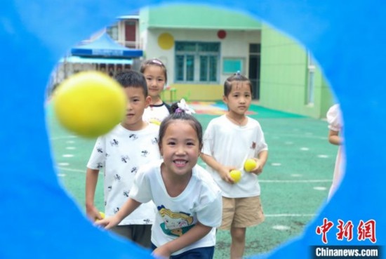 在肥西縣山南鎮(zhèn)中心幼兒園，孩子們在玩布洞投球游戲。陳家樂 攝