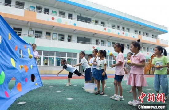 在肥西縣山南鎮(zhèn)中心幼兒園，孩子們在玩布洞投球游戲。陳家樂 攝