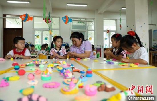 在肥西縣山南鎮(zhèn)中心幼兒園，孩子們在老師的指導(dǎo)下做彩色泥塑。陳家樂 攝
