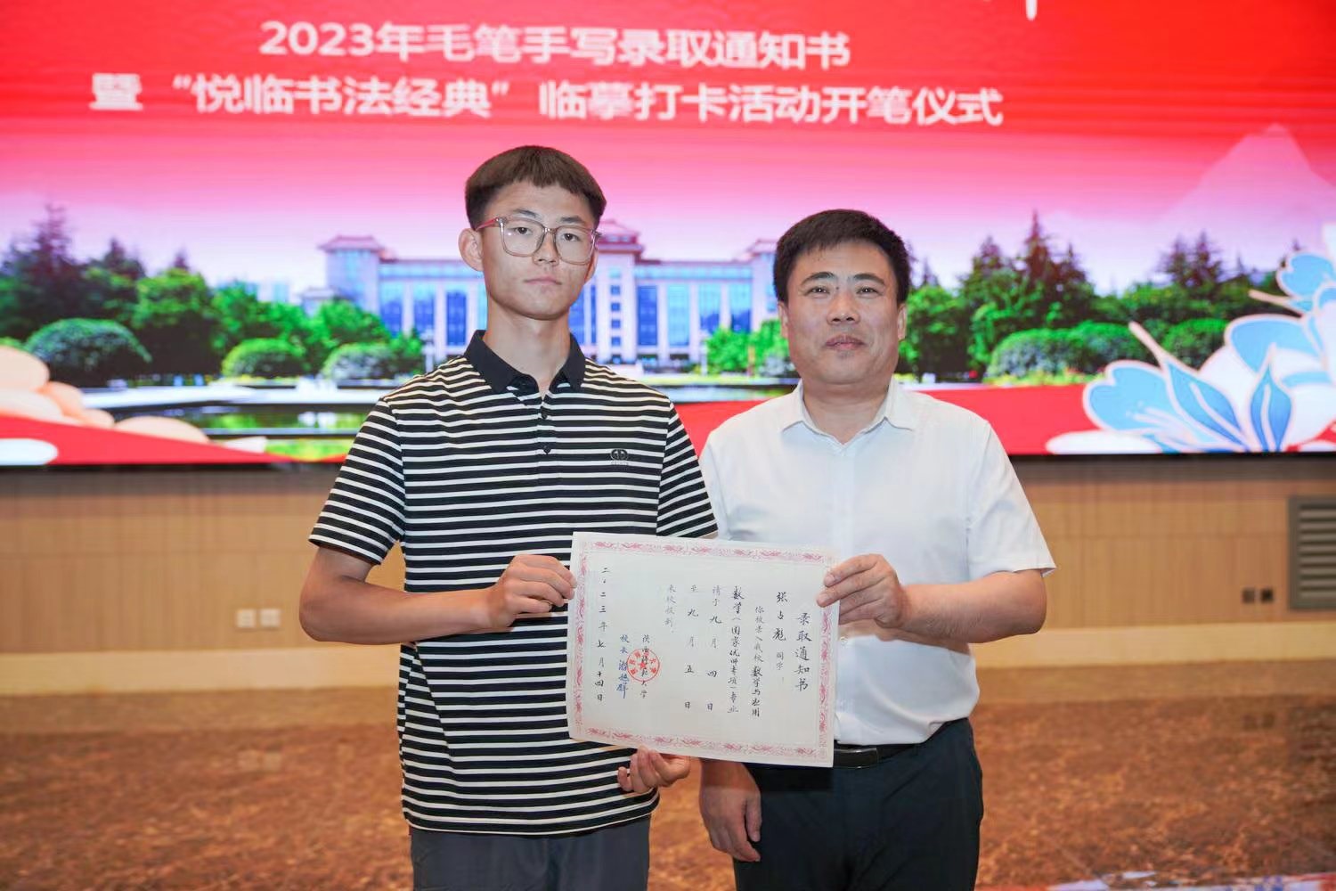 陜西師范大學(xué)黨委書記李忠軍為2023級新生代表張占彪同學(xué)發(fā)放錄取通知書。校方供圖