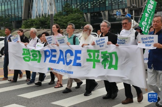7月22日，在韓國首爾，人們手舉標(biāo)語參與反戰(zhàn)游行。新華社發(fā)（楊暢 攝）