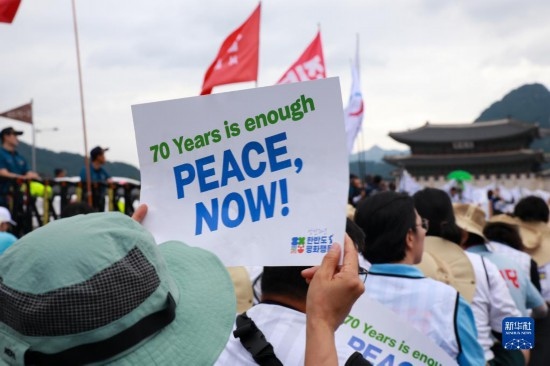 7月22日，在韓國首爾，人們手舉標(biāo)語參與反戰(zhàn)游行。新華社發(fā)（楊暢 攝）