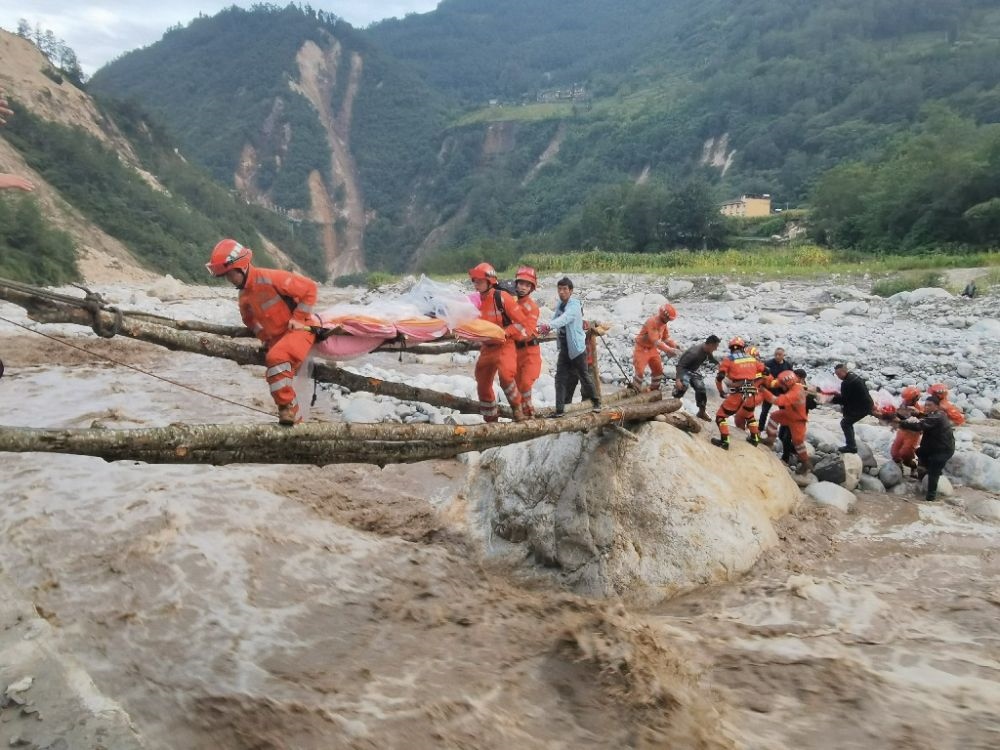 ↑2022年9月5日，武警四川總隊(duì)機(jī)動(dòng)第二支隊(duì)官兵在甘孜州瀘定縣磨西鎮(zhèn)磨子溝村搭建臨時(shí)木橋轉(zhuǎn)移被困群眾（手機(jī)照片）。新華社發(fā)（洪福樂 攝）