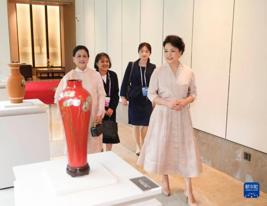 7月27日下午，國(guó)家主席習(xí)近平夫人彭麗媛在四川成都會(huì)見(jiàn)陪同印度尼西亞總統(tǒng)佐科來(lái)華出席第31屆世界大學(xué)生夏季運(yùn)動(dòng)會(huì)開(kāi)幕式并訪華的總統(tǒng)夫人伊莉亞娜。這是彭麗媛和伊莉亞娜欣賞成都特色非遺工藝品。新華社記者 丁林 攝