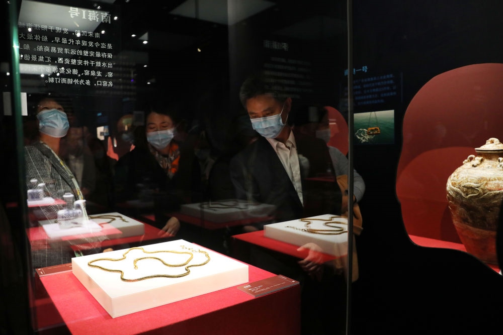 參觀者在上海臨港新城的中國航海博物館航海文物展上的“南海一號”出水的宋代金項飾展柜前駐足觀看（2020年12月28日攝）。新華社記者 方喆 攝
