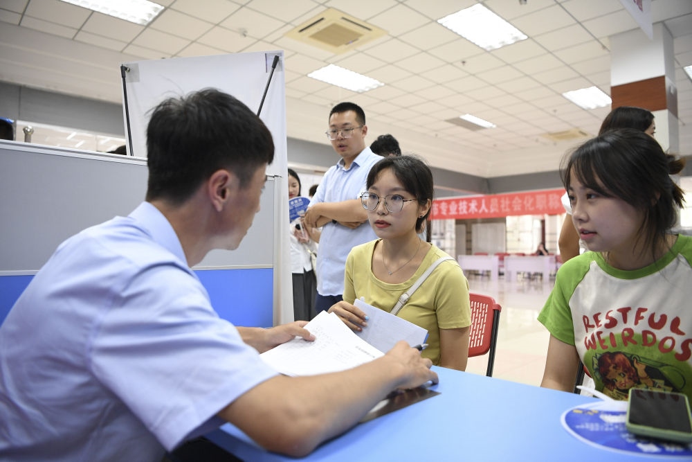 2023年7月29日，“揚(yáng)就業(yè)之帆，啟夢(mèng)想之旅”2023年寧夏（銀川）離校未就業(yè)高校畢業(yè)生招聘會(huì)在寧夏（銀川）人力資源服務(wù)產(chǎn)業(yè)園舉行。求職者（右）在招聘會(huì)現(xiàn)場(chǎng)與用人單位交流。新華社記者 馮開(kāi)華 攝