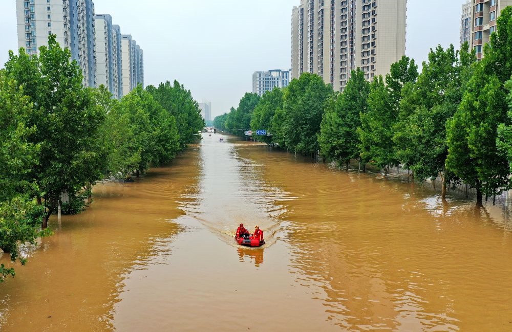 救援人員在河北省涿州市市區(qū)乘坐沖鋒舟前去轉(zhuǎn)移受災(zāi)群眾（8月2日攝，無(wú)人機(jī)照片）。新華社記者 牟宇 攝