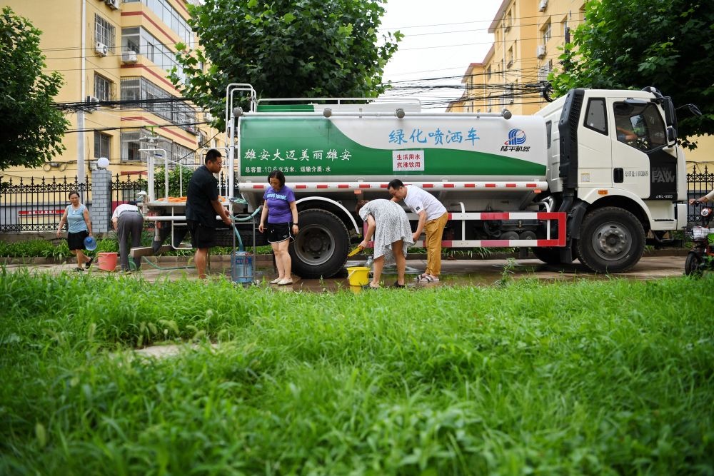 河北省涿州市新星小區(qū)居民從供水車(chē)?yán)锝铀?月4日攝）。新華社記者 牟宇 攝
