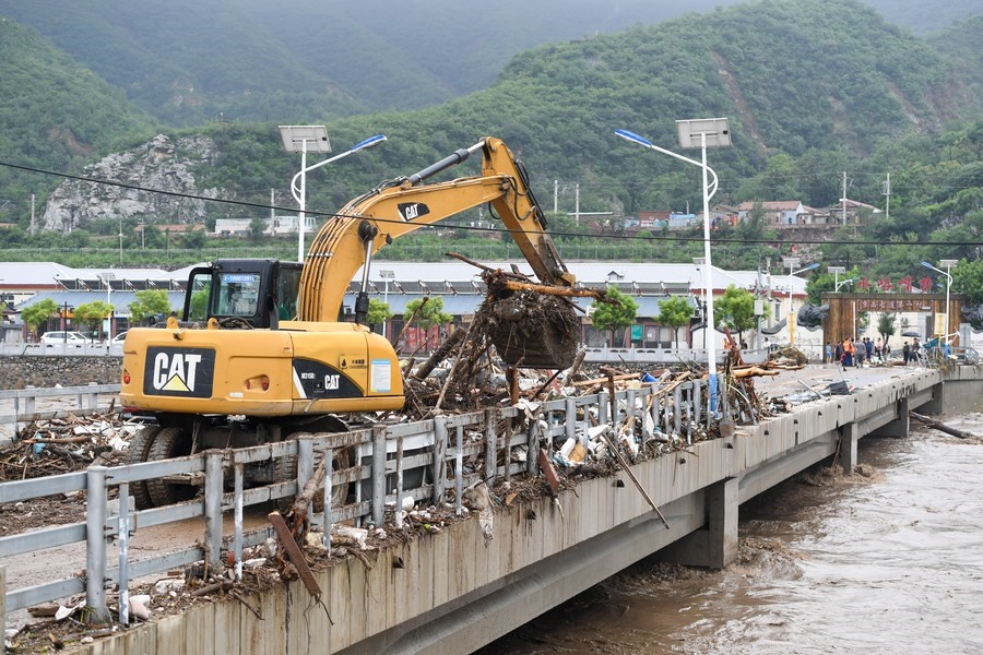 8月1日，在北京市門頭溝區(qū)水峪嘴村村口，一臺挖掘機在清理阻斷橋梁交通的雜物。目前該條道路已經(jīng)疏通完成。新華社記者 鞠煥宗 攝