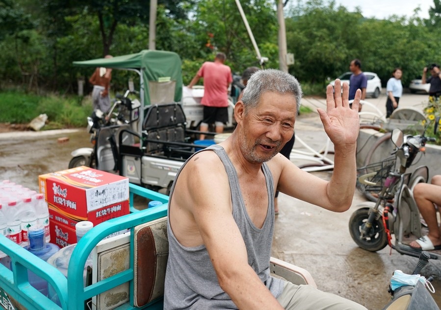 8月5日，從安置點回來的北京市房山區(qū)青龍湖鎮(zhèn)口頭村村民高大爺領到生活物資準備回家。新華社記者 張晨霖 攝