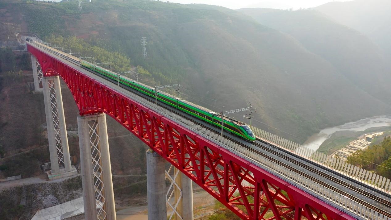 中老鐵路國際旅客列車在云南省境內(nèi)的元江特大橋上飛馳。姚巍攝