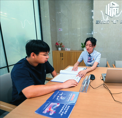在杭州市臨安區(qū)政務(wù)服務(wù)中心的“為企服務(wù)中心”，黨員志愿者（右）解答企業(yè)主的疑問（2023年7月7日攝）。徐昱攝/本刊