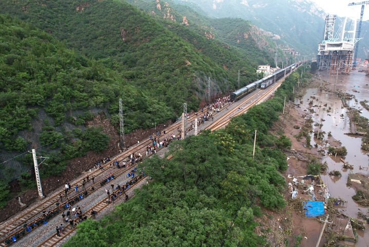 8月2日，受困列車旅客在救援人員幫助下徒步趕往轉(zhuǎn)運(yùn)客車（無人機(jī)照片）。新華社記者 張晨霖 攝