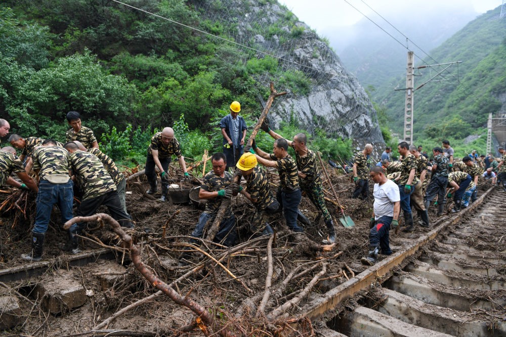 8月1日，在北京市門頭溝區(qū)水峪嘴村附近一段被阻斷的鐵路線上，中鐵六局工作人員在清理軌道上的雜物，全力恢復(fù)交通。新華社記者 鞠煥宗 攝