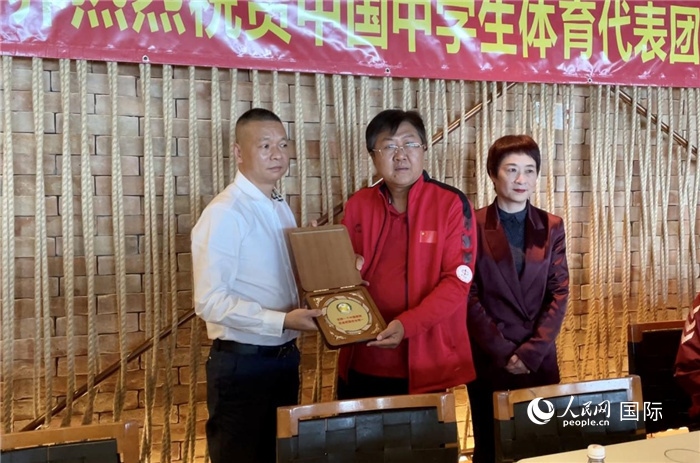 巴西中國和平統(tǒng)一促進會會長王俊曉向中國中學(xué)生體育代表團團長劉立新贈送紀念品。人民網(wǎng)記者 宋亦然攝