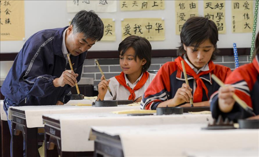 △新疆疏附縣托克扎克鎮(zhèn)中心小學書法教室內(nèi)，同學們正在學習寫毛筆字。