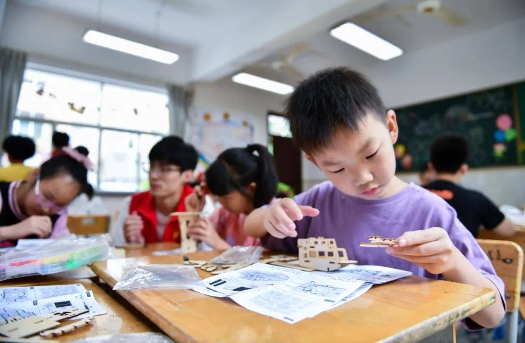 △今年7月，在浙江余姚市舜北小學暑托班內(nèi)，孩子們制作太陽能科學實驗裝置。