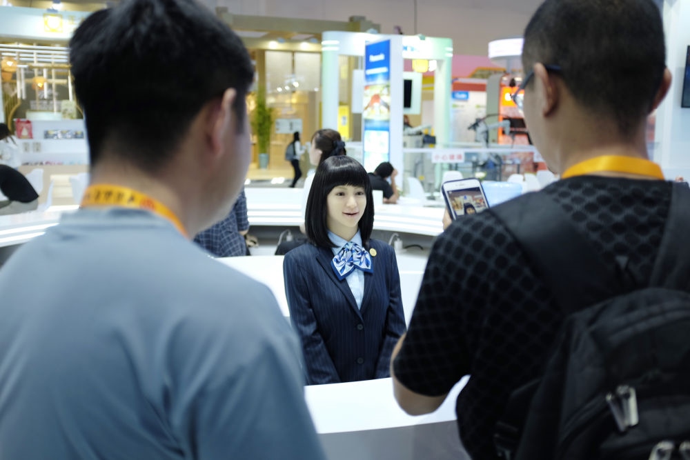 9月1日，媒體記者在國家會議中心與服務(wù)機器人互動。新華社記者 劉夢琪 攝