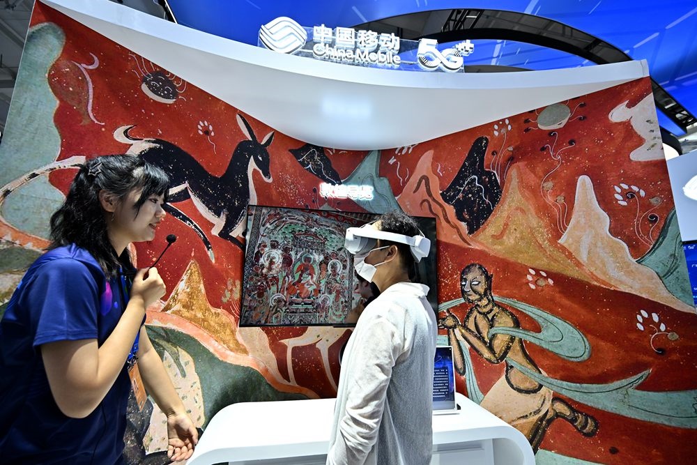 9月3日，一名參觀者在首鋼園中國移動展臺體驗(yàn)基于AR/VR特效的敦煌導(dǎo)覽，沉浸式感受敦煌壁畫的魅力。新華社記者 李鑫 攝