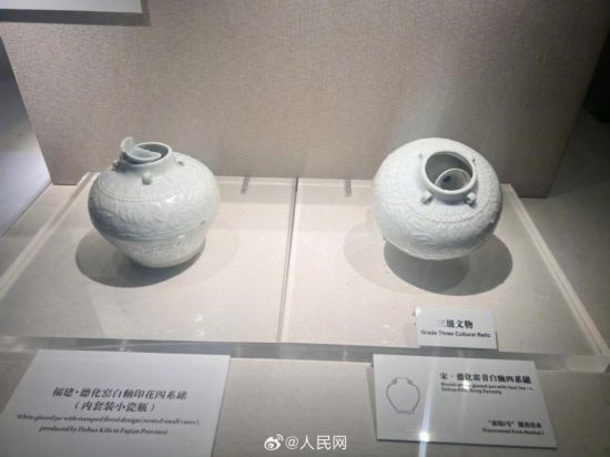 福建德化窯白釉印花四系罐（左）。人民網(wǎng)記者 李娜攝