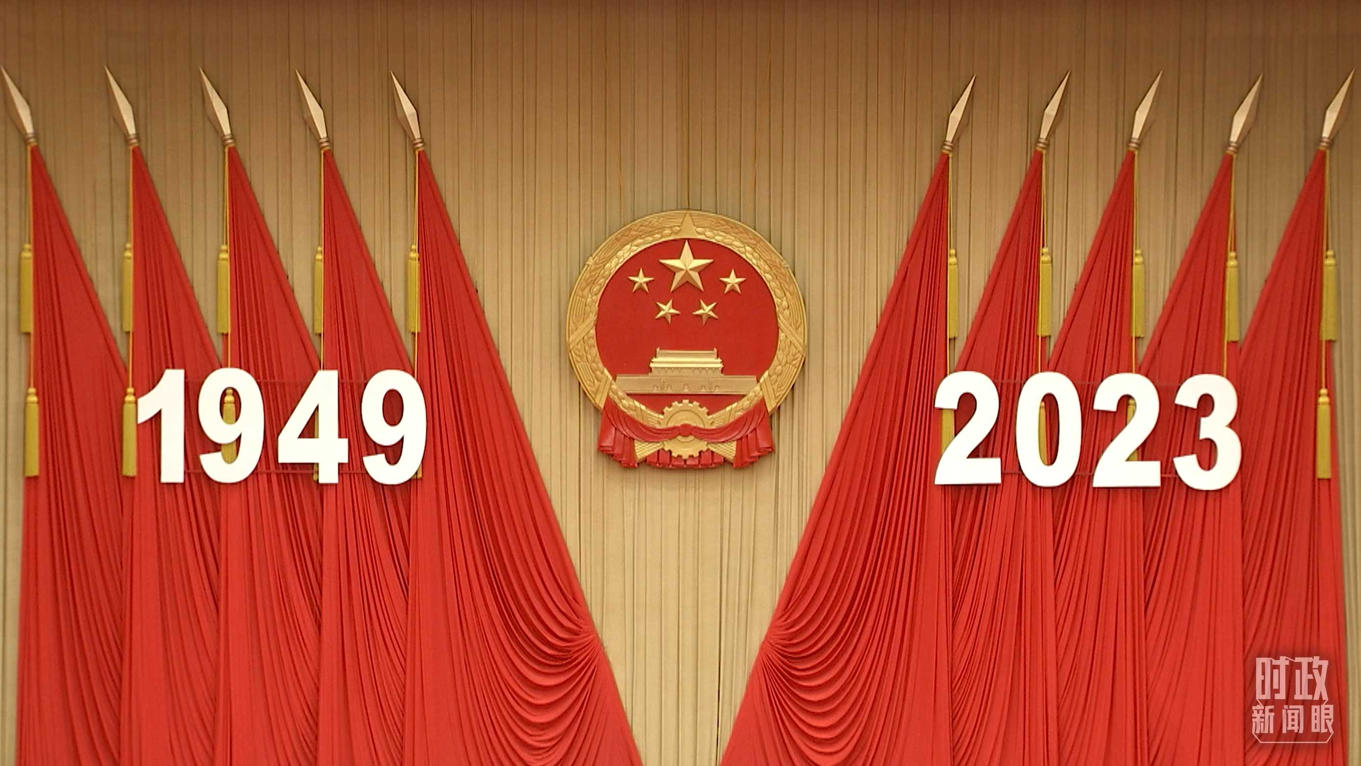 △人民大會(huì)堂宴會(huì)廳內(nèi)，主席臺(tái)上方高懸著莊嚴(yán)的國徽，“1949－2023”大字年號(hào)在鮮艷的紅旗映襯下格外醒目。