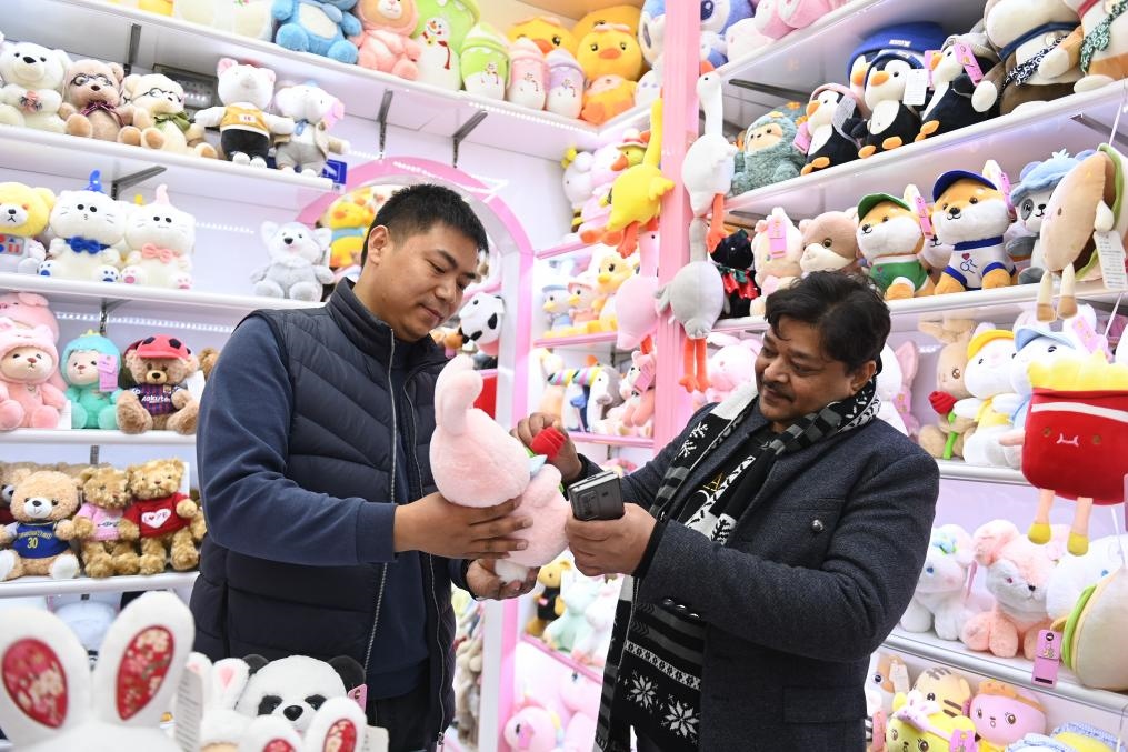 2023年2月2日，來自印度的客商（右）在義烏國際商貿(mào)城的一家玩具店鋪內(nèi)選購商品。新華社記者 黃宗治 攝