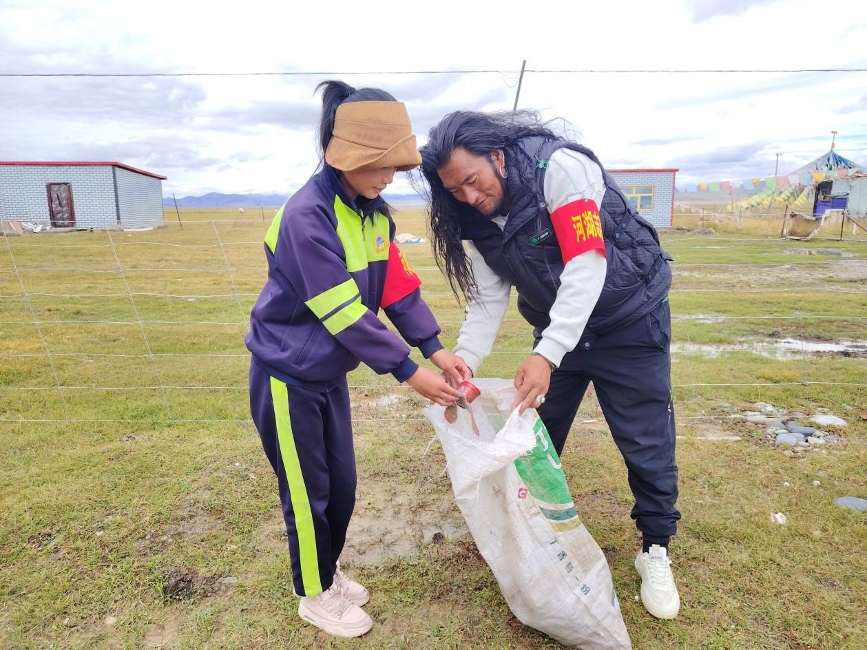 玉樹州稱多縣珍秦鎮(zhèn)河湖志愿者才培和他女兒更求拉毛在清掃垃圾。受訪者供圖