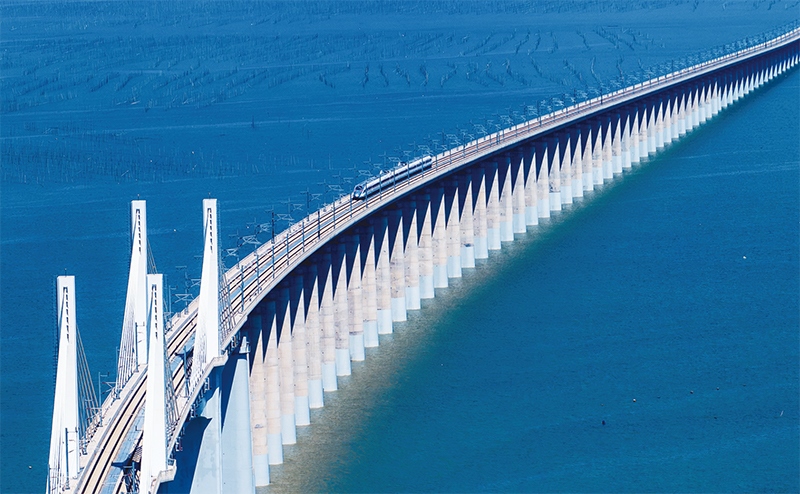 2023年9月28日，中國首條時速350公里跨海高鐵——福廈高鐵正式開通運營。圖為一列運行試驗車組駛過福廈高鐵湄洲灣跨海大橋（9月19日攝，無人機照片）。 新華社記者 魏培全/攝