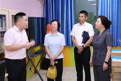 圖③：“小公民法律課堂”開講前，全國人大代表殷其龍（右二）、重慶市人大代表李自玲（左二）聽取楊家坪中學負責人關于未成年人思想教育工作情況的介紹。